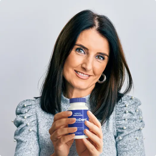 Woman holding ProvaDent oral probiotic bottle how it works